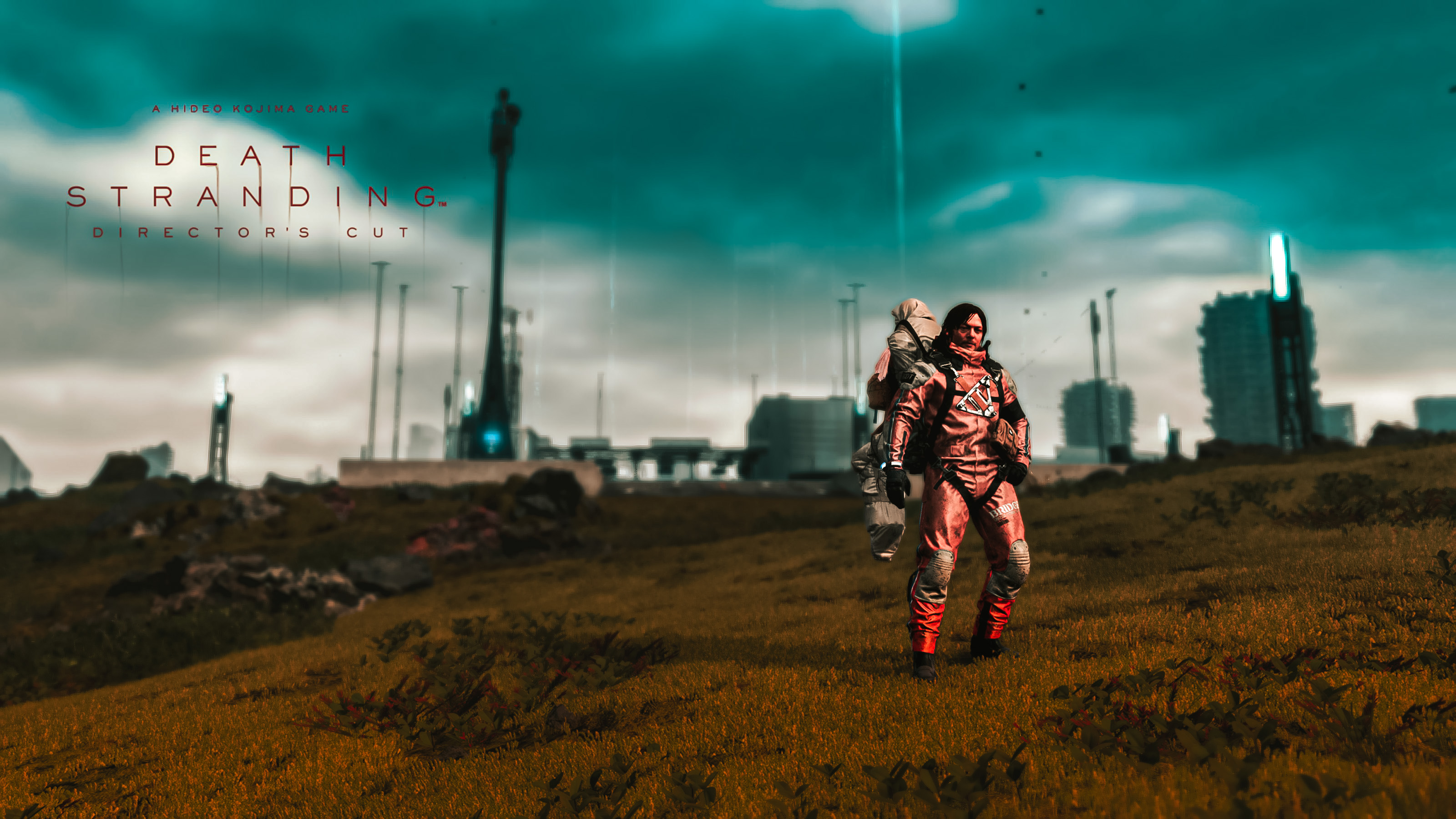 a picture of Sam from Death Stranding standing in front of a city, in a field with a corpse on his back, the death stranding director's cut logo is in the top left of the picture